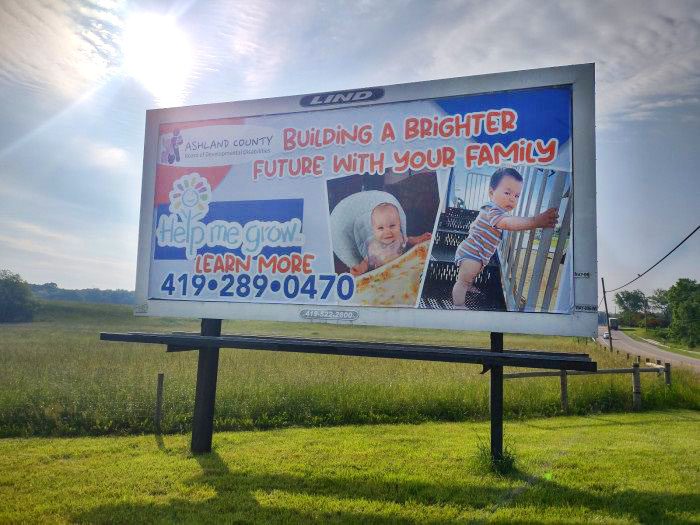 Photo of a Lind Billboard with an image of a baby and a flower logo with the text "Building a Brighter Future With Your Family-Ashland County Board of Developmental Disabilities"