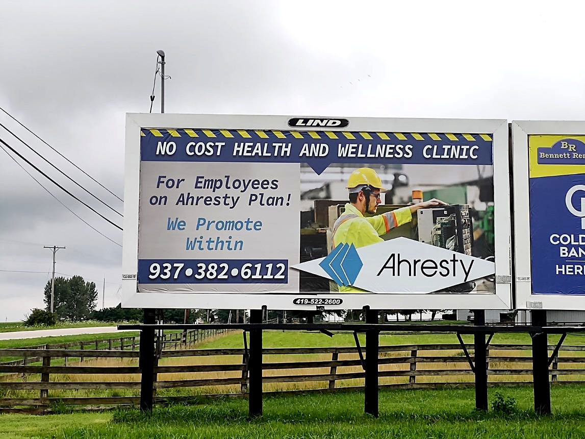 Photo of a Lind Billboard with an image of an industrial worker and the text "Ahresty-No Cost Health and Wellness Clinic"