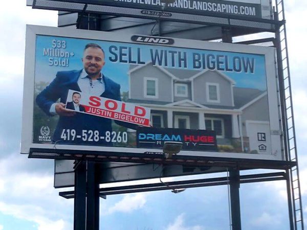 A standard sized billboard with the dream huge realtor selling a beautiful home for his team.